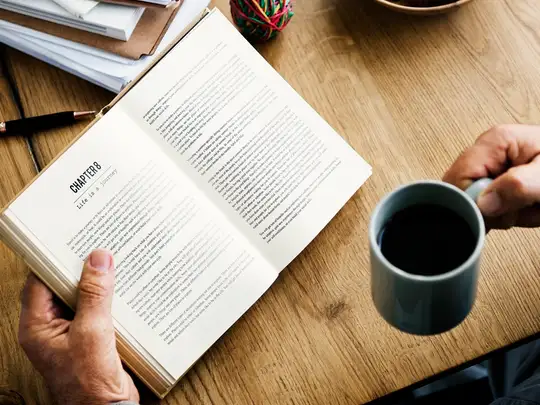 Un livre ouvert et une tasse de café sur une table