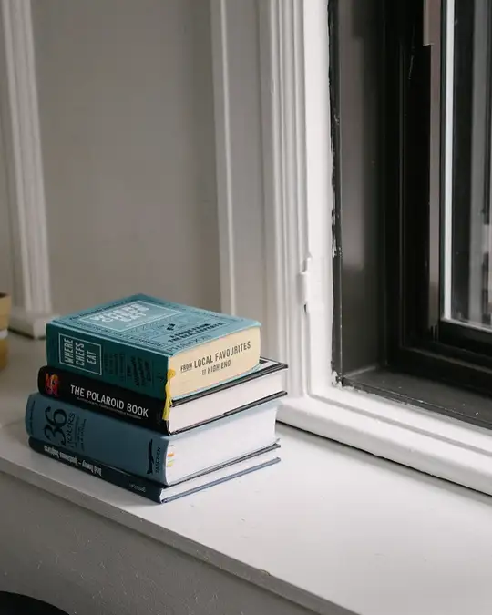 Une pile de livres au bord d'une fenêtre